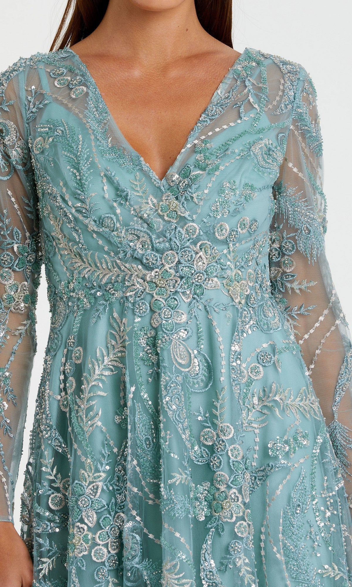 A woman models the Midi Party Dress: Mac Duggal 68915โa teal, sheer, long-sleeve dress featuring intricate floral embroidery and beadworkโshown from mid-thigh to shoulders.